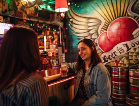 Two people enjoying drinks at Golding's Free Dive, a cool, kitsch, and cosy laneway bar in Te Aro, Wellington.