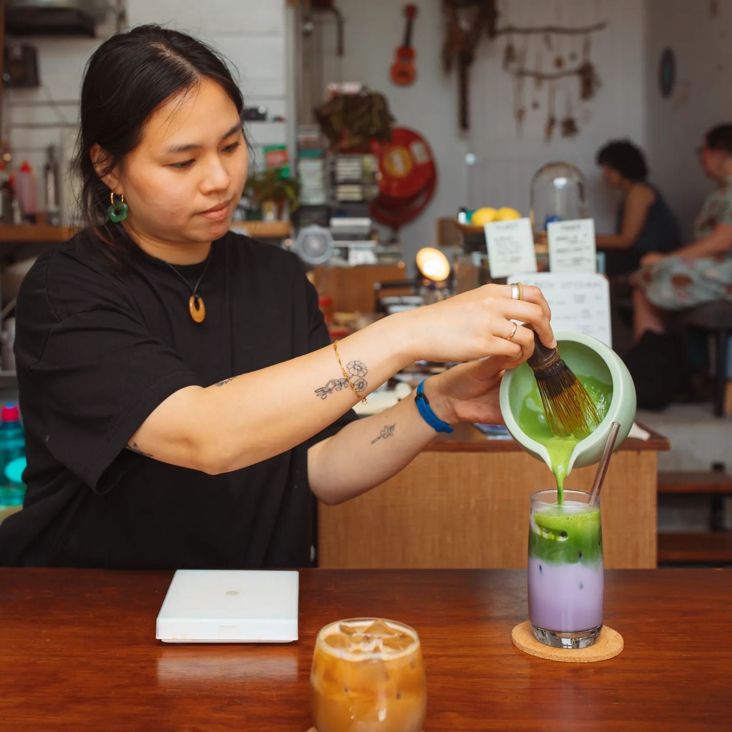 A barista prepares an iced pink matcha at Pour & Twist.
