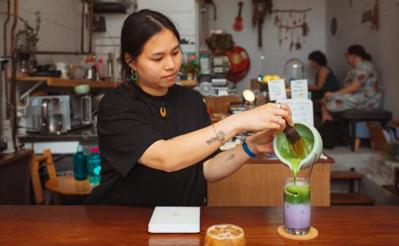 A barista prepares an iced pink matcha at Pour & Twist.