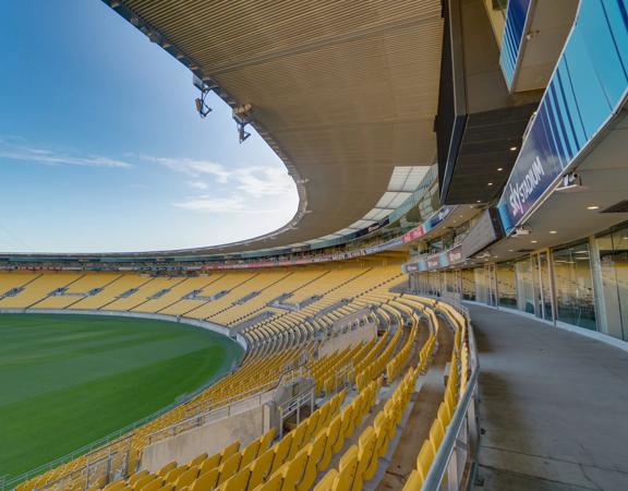 Looking out over the green field at sky stadium, over the yellow seats from the Sky Stadium function centre box.