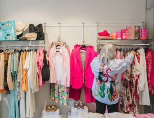 A shopper browses the clothing racks at Hamilton & Murray Boutique.