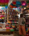 Two individuals shopping at Iko Iko, a gift store on Cuba Street in Te Aro Wellington. The shop is full of colourful crafts, décor, books and other items.