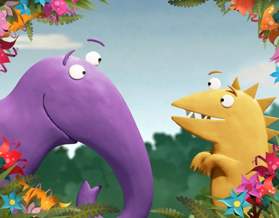 The two main characters from the animated children's TV show Kiri and Lou look at each other behind a frame of flowers
