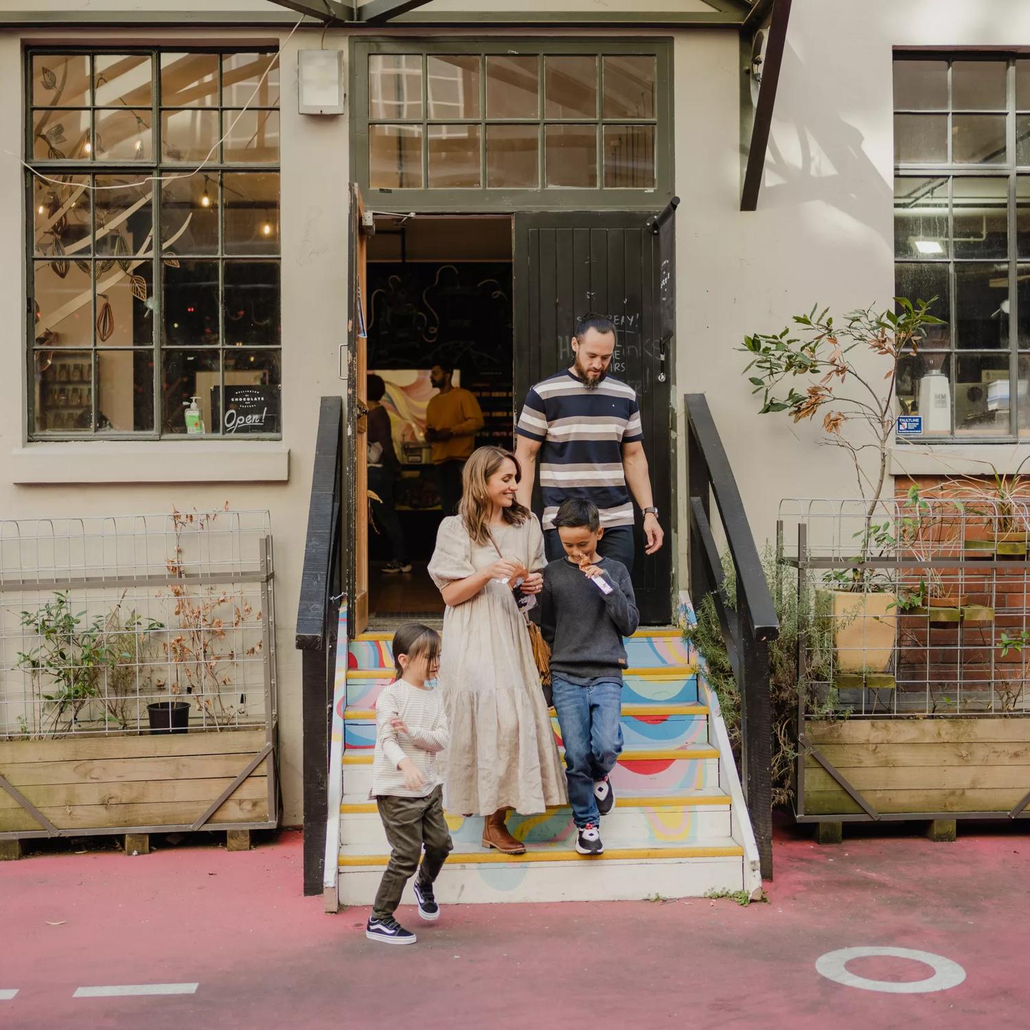 A family walks down the rainbow steps outside the chocolatefactory in Hannahs Laneway.