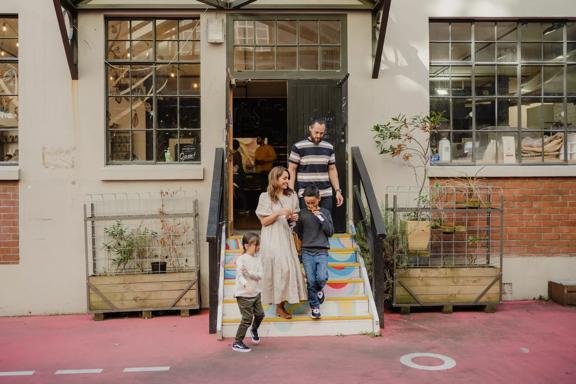 A family walks down the rainbow steps outside the chocolatefactory in Hannahs Laneway.