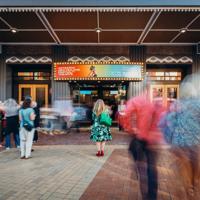 Festival attendees gather outside of St James Theatre with the Aotearoa New Zealand Arts Festival displayed on the marquee.