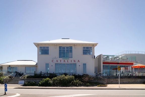 Exterior of Hotel Catalina, a large wooden building directly opposite Lyall Bay beach.