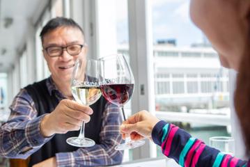 2 people clinking glasses of wine at Dockside restaurant & Bar.