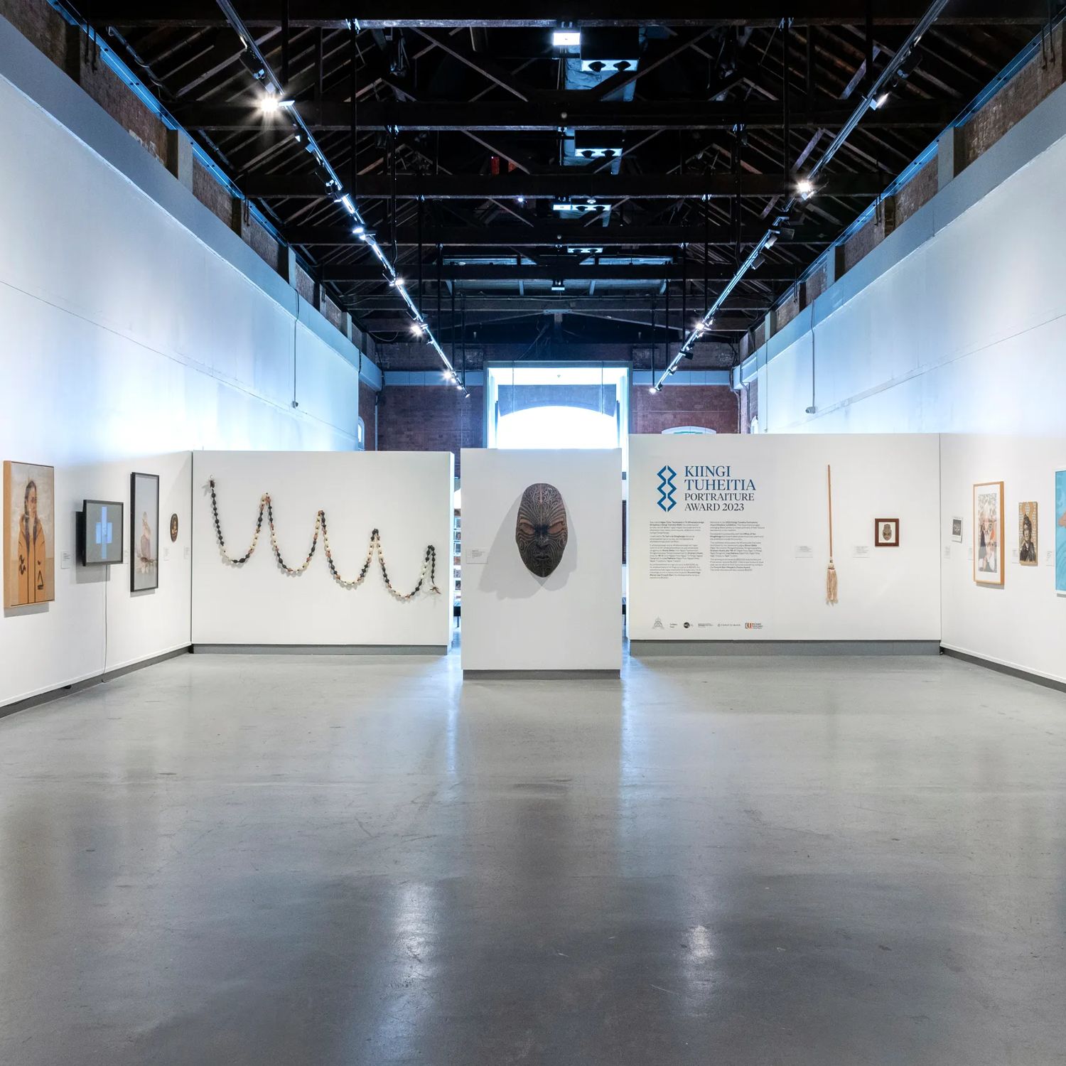 Interior of the New Zealand Portrait Gallery Te Pūkenga Whakaata in Wellington, featuring portrait artworks displayed along white gallery walls in a spacious exhibition hall.