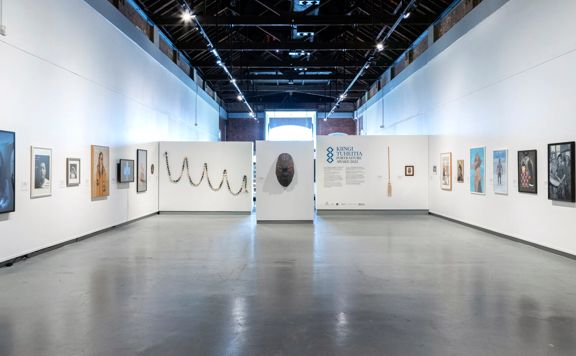 Interior of the New Zealand Portrait Gallery Te Pūkenga Whakaata in Wellington, featuring portrait artworks displayed along white gallery walls in a spacious exhibition hall.