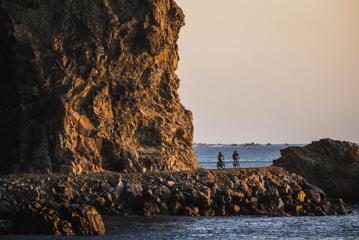 2 bikers on the Pencarrow Coast Road at sunset.