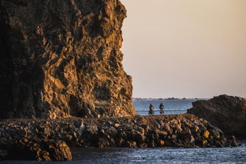 2 bikers on the Pencarrow Coast Road at sunset.
