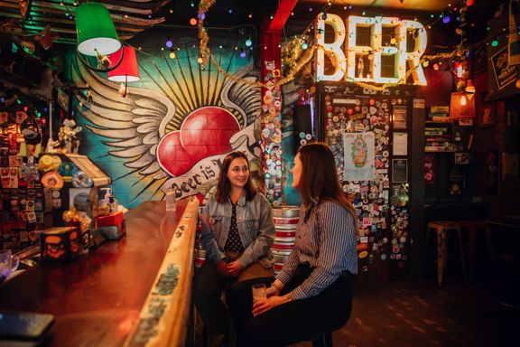 Two people enjoying drinks at Golding's Free Dive, a cool, kitsch, and cosy laneway bar in Te Aro, Wellington.
