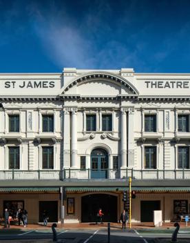 The front facade of the St James Theatre located on Courtney Place in Wellington's city centre. It's a white, three-story building with teal awning. 