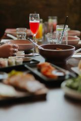 A spread of Asian fusion dishes and cocktails on a table.