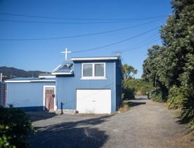 The Petone boat ramp, Hikoikoi,  with colourful boat sheds and boats in the morning sun.