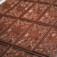 Artisanal dark chocolate bars, imprinted with a floral design, on a baking sheet at the Wellington Chocolate Factory.