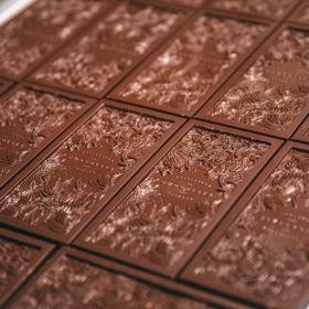 Artisanal dark chocolate bars, imprinted with a floral design, on a baking sheet at the Wellington Chocolate Factory. 