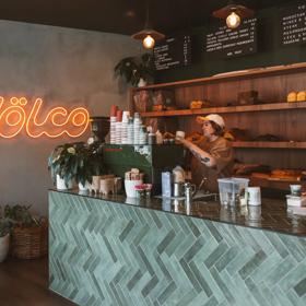 Inside Volco, a bakery in Kelburn Wellington, a worker behind the espresso machine prepares a coffee for takeaway.