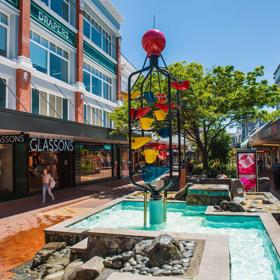 People walking down Cuba Street, past the Bucket Fountain, an iconic kinetic sculpture.