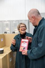 Two people in blue coast sharing a box of cranberry and coconut-flavoured grain crisps.