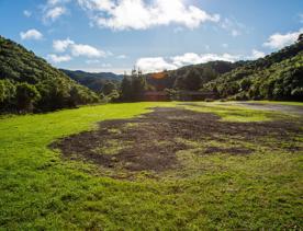 Camp Wainuiomata screen location. Has several buildings and is surrounded by forest and bush.