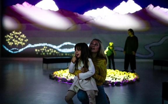 A young child and their parent enjoy the lights inside one of the Dowse Museum exhibits.