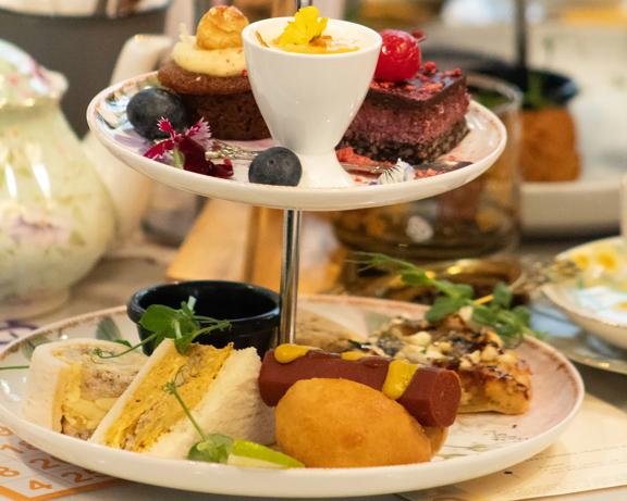 A cake stand holds finger food for high tea.