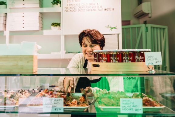Person at Slice serving up a slice of pizza