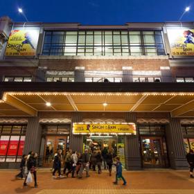 Looking up at St James theatre from the road, as people walk inside to enjoy a show.