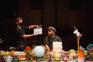 Director Aditya B. Parige on the set of the 'Diverse Voices' filming, with a crew member holding a clap board in front of him.