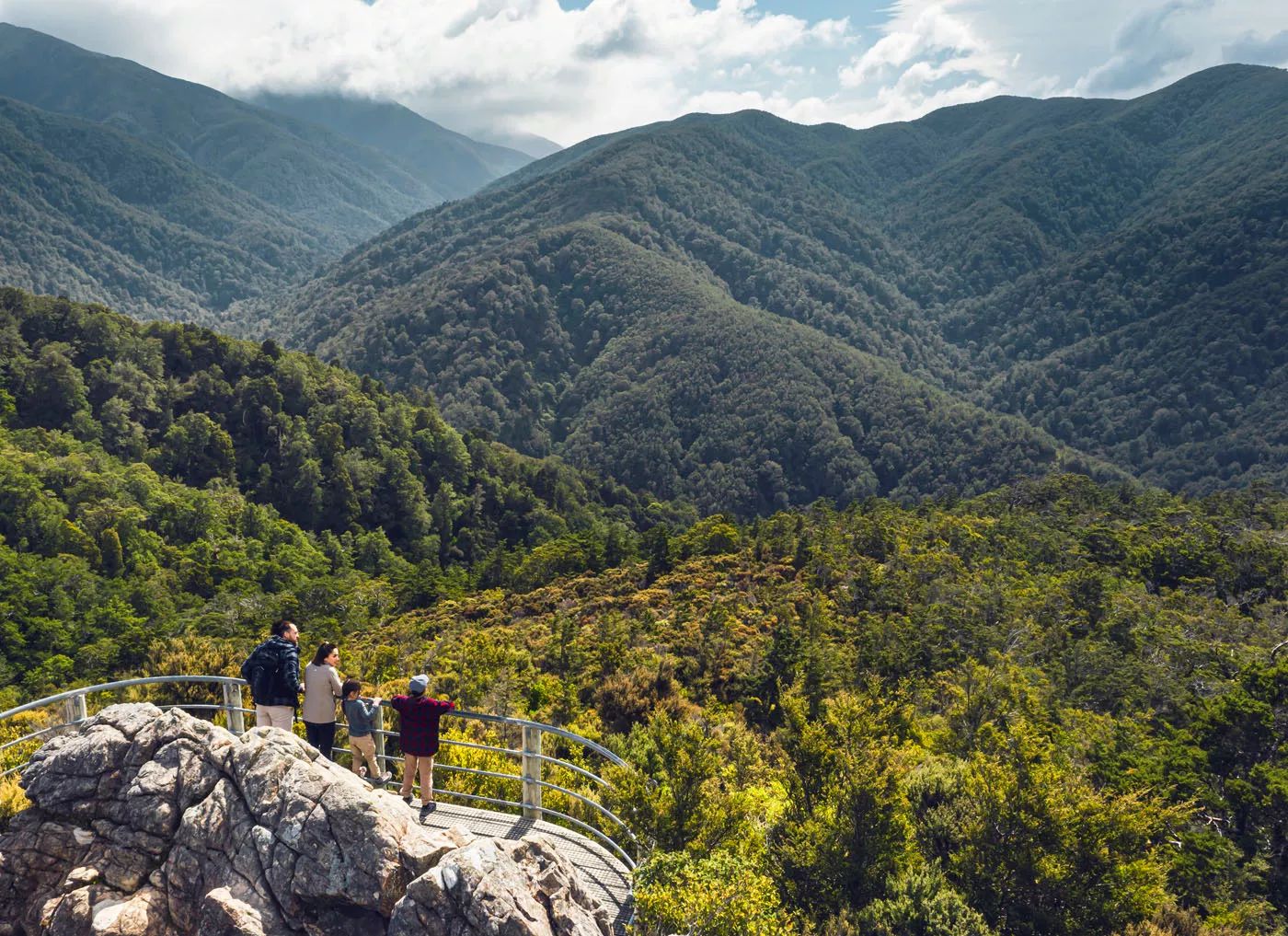Two adults and two children are at the Rocky Lookout, on Mount Holdsworth in the Tararua Forest Park.