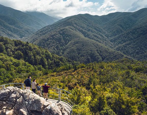 Two adults and two children are at the Rocky Lookout, on Mount Holdsworth in the Tararua Forest Park.