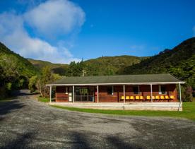 Camp Wainuiomata screen location. Has several buildings and is surrounded by forest and bush.