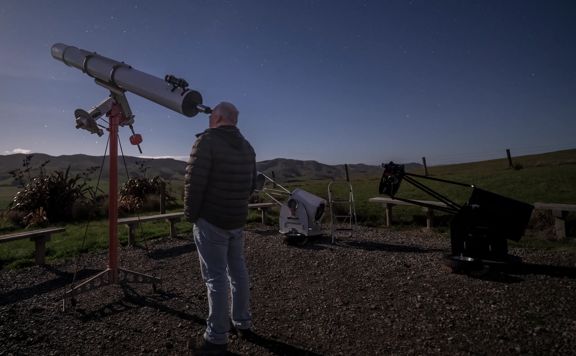 A person looks through a telescope at the sky at Star Safari, an astrotourism business based out of Carterton.