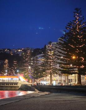 The screen location of Oriental Bay, wth pastel-coloured, Art Deco apartments, brightly-painted boat sheds, and the golden beach.