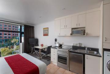 Inside a room at Quest on the terrace, with a kitchenette and a bed.