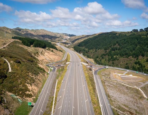 The 4 lane motorway of Transmission Gully, surrounded by green hills.