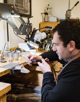 The workshop area of Rawson brothers Jewellery, where a worker is heating up a piece of metal to turn into a ring.