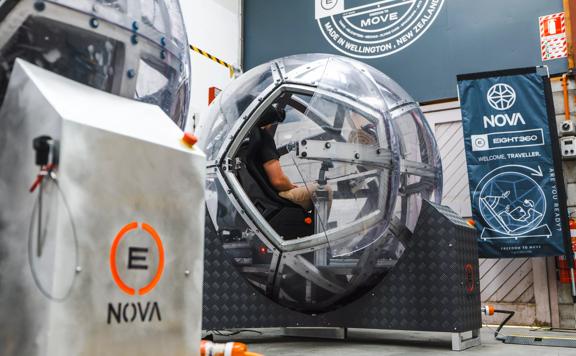 A person sits inside a NOVA, a large plastic sphere with virtual reality capabilities at eight360, a Wellington-based tech company.