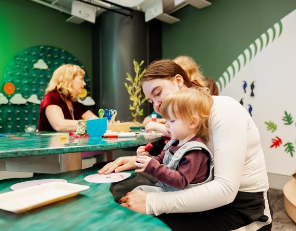 A child and a caregiver using an art station at Capital E in Wellington