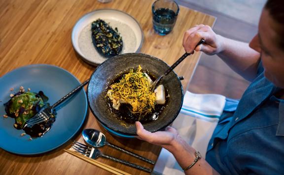 A customer serving their plate of food at Koji.