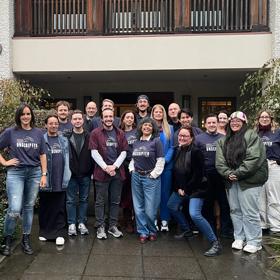 A group of students smiling standing outside a film post production studio