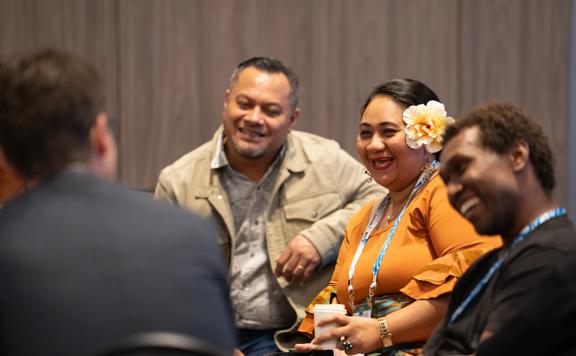 People talk in a group at APNIC 58 at Tākina.