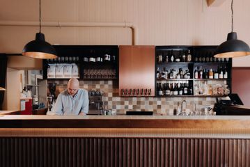 A bartender standing behind a bar.