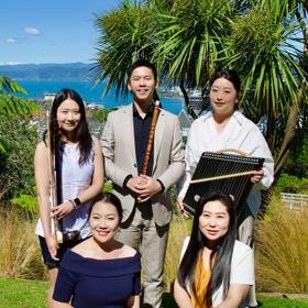 The five members of the Eastern Echoes Ensemble pose with their instruments with a view of Wellington harbour behind them.