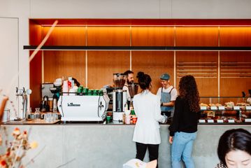 Two people place their order at the counter at Sketchbook Coffee.