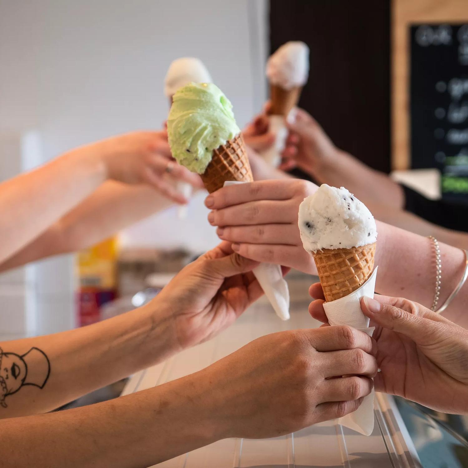 4 ice creams being handed over the counter at Gelissimo Gelateria.