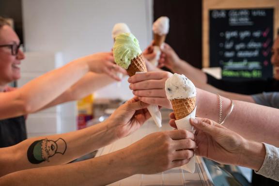 4 ice creams being handed over the counter at Gelissimo Gelateria.
