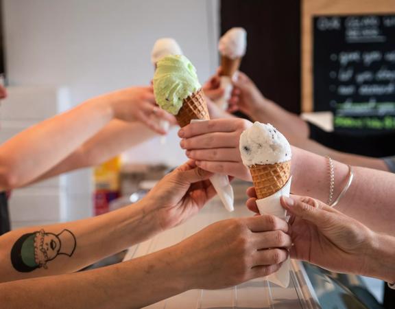 4 ice creams being handed over the counter at Gelissimo Gelateria.